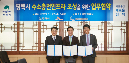 27일 경기도 평택시청에서 열린 '평택시 수소충전인프라 조성을 위한 업무협약식'에 참석한 (좌측부터) 유종수 HYNET 대표, 정장선 평택시장, 심두섭 SK에너지 B2C사업본부장이 협약서에 서명 후 기념 사진을 촬영하고 있다. <SK이노베이션 제공>